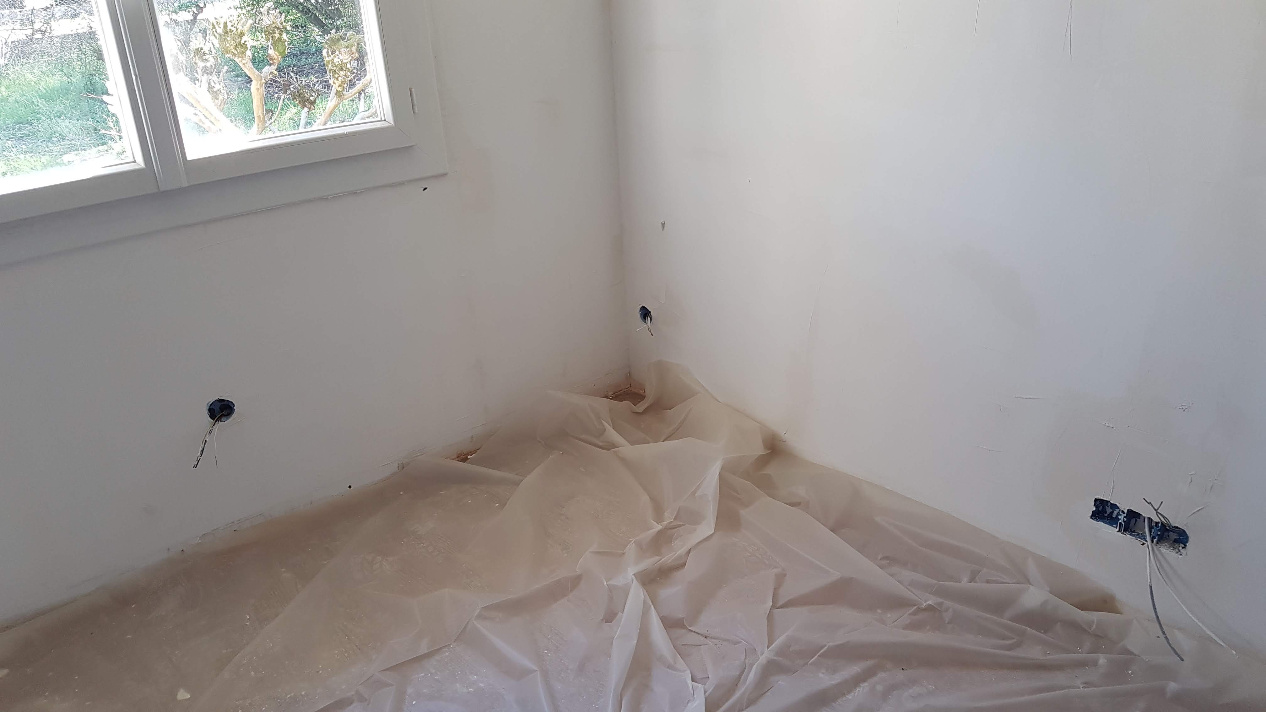 Mur bleu et blanc avec gaines électriques pendant une rénovation