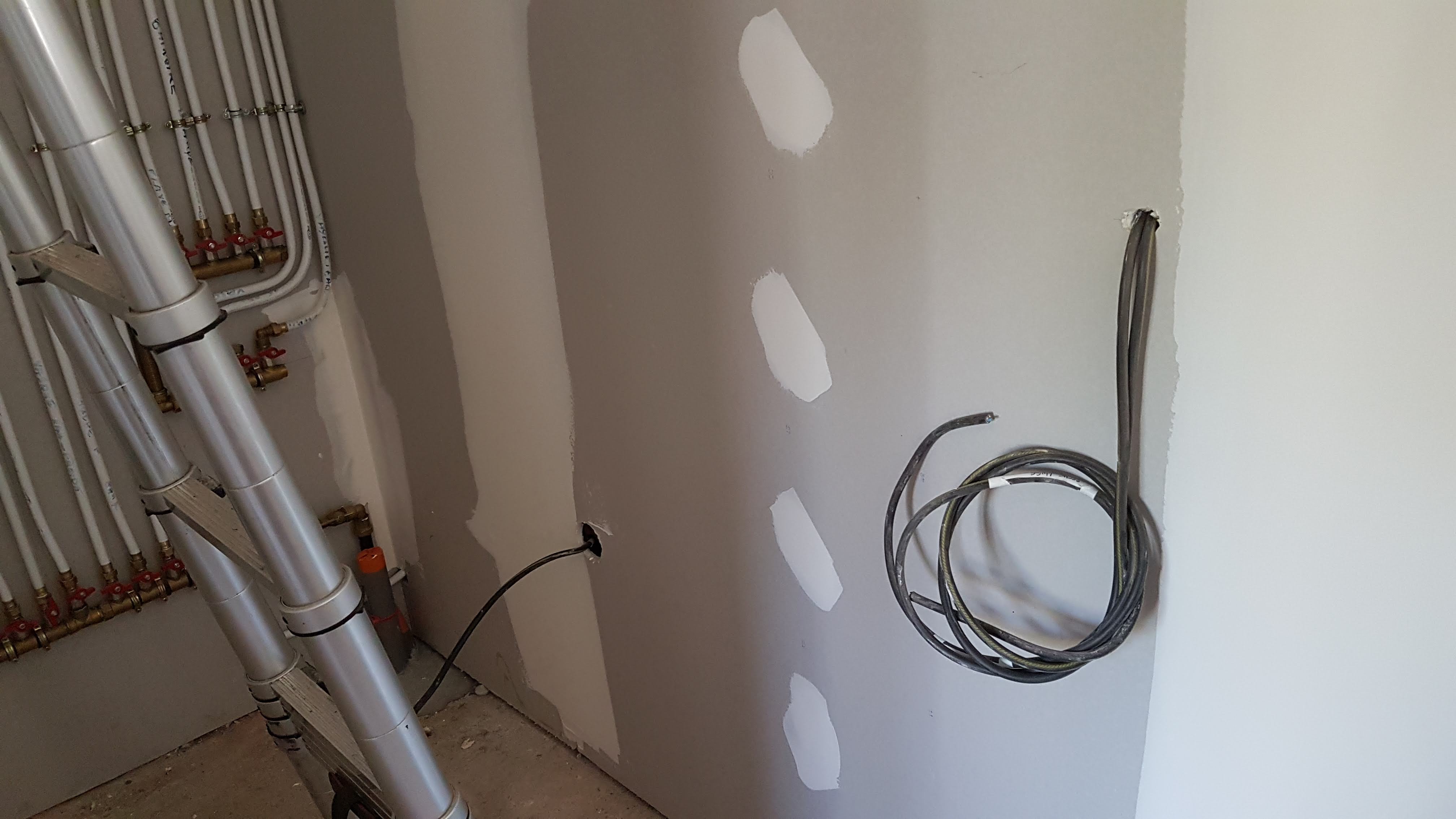 Mur de rénovation avec baie vitrée et gaines vertes