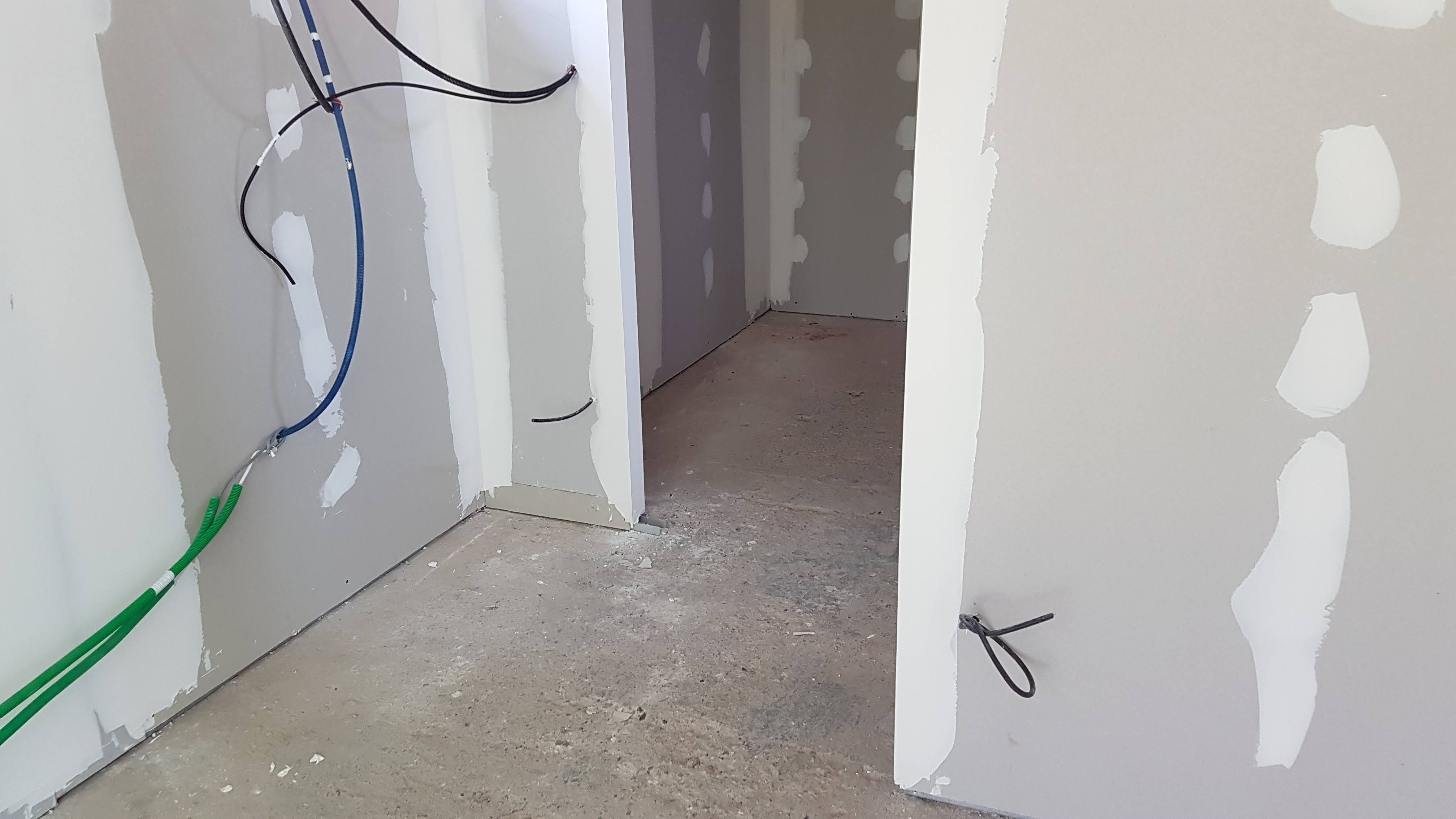 Pièce en rénovation avec porte-fenêtre et alimentations électriques